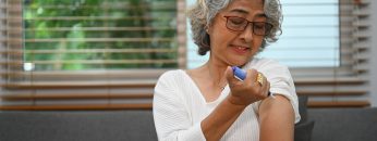 Diabetic senior woman injecting insulin shot into her upper arm. Diabetes, healthcare.